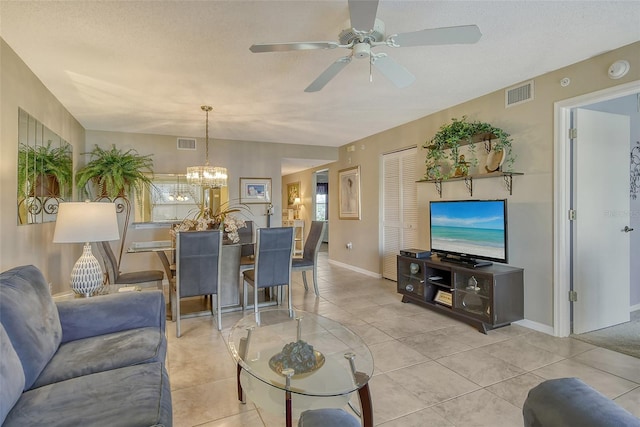 tiled living room with ceiling fan with notable chandelier and a textured ceiling