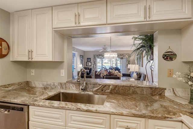 kitchen featuring light stone counters, stainless steel dishwasher, ceiling fan, and sink