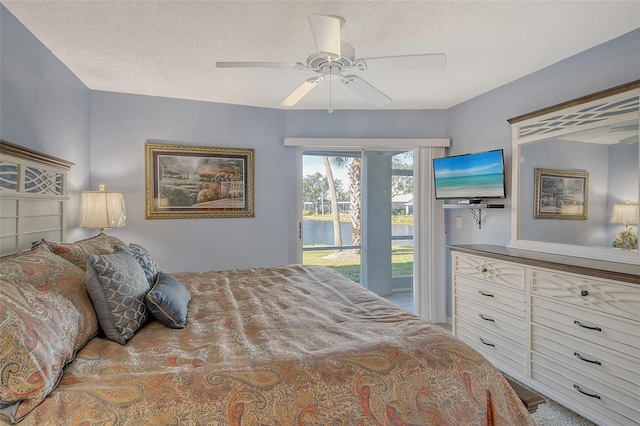 bedroom featuring ceiling fan, access to outside, and a textured ceiling