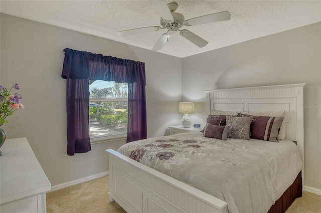 carpeted bedroom featuring ceiling fan and a textured ceiling