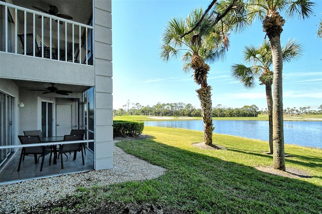 view of yard featuring a balcony, a patio, ceiling fan, and a water view