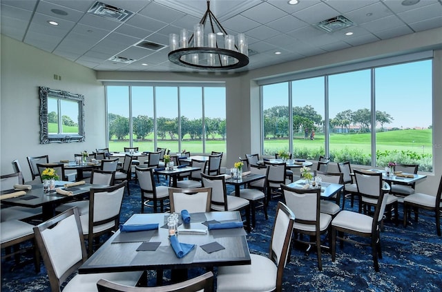 dining space with a paneled ceiling, a towering ceiling, and a notable chandelier