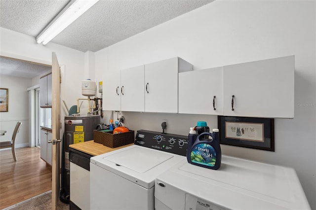 clothes washing area with independent washer and dryer, dark hardwood / wood-style flooring, electric water heater, and a textured ceiling