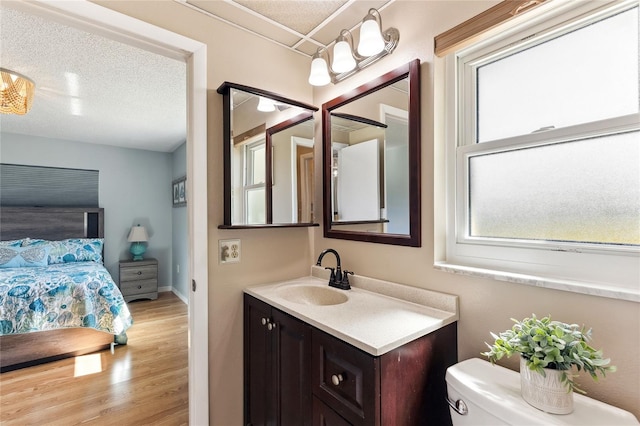 bathroom featuring vanity, toilet, hardwood / wood-style floors, and a textured ceiling