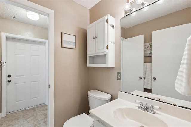 bathroom with vanity, a textured ceiling, and toilet