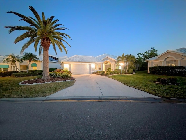 view of front facade featuring a garage and a yard