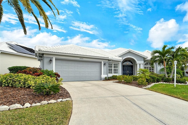 ranch-style home featuring a garage and a front lawn