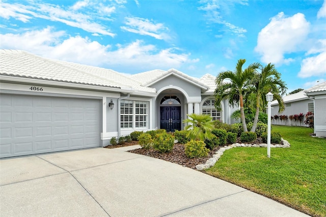 ranch-style house featuring a garage and a front lawn