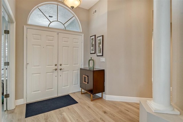 entryway with decorative columns and light wood-type flooring