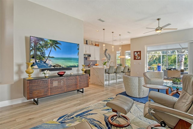 living room featuring ceiling fan and light wood-type flooring