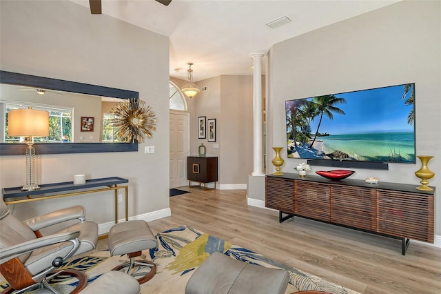 living room with ceiling fan, light wood-type flooring, and ornate columns