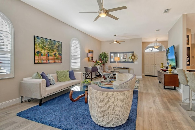 living room featuring ceiling fan, a healthy amount of sunlight, and light wood-type flooring