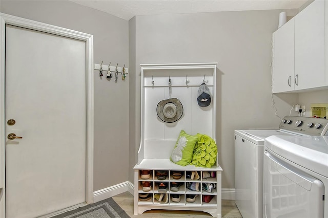 washroom with washer and clothes dryer and light hardwood / wood-style floors