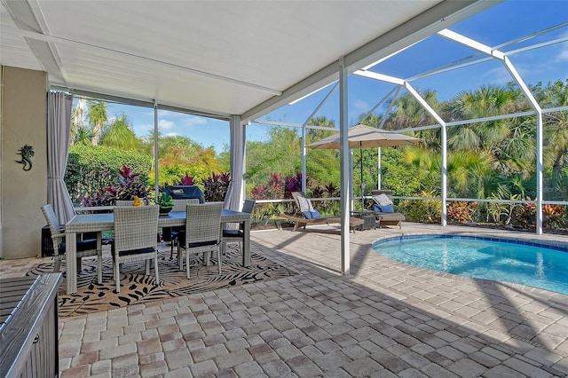 view of swimming pool featuring glass enclosure and a patio area