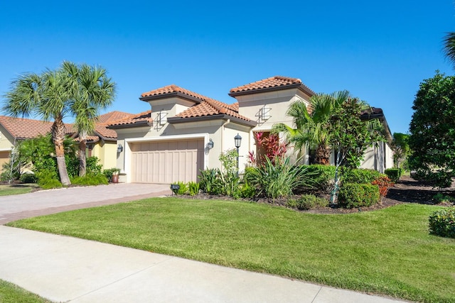 mediterranean / spanish-style house featuring a garage, a tile roof, decorative driveway, stucco siding, and a front yard