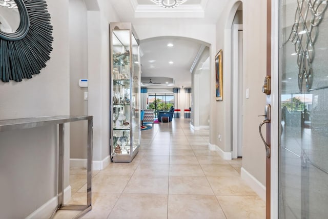 corridor featuring ornamental molding and light tile patterned floors