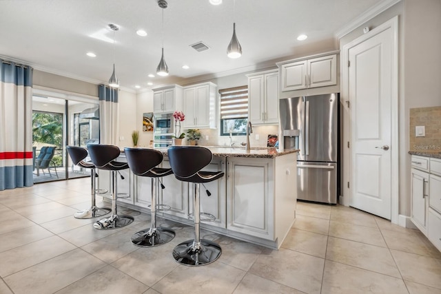 kitchen with white cabinetry, stainless steel appliances, and a kitchen island