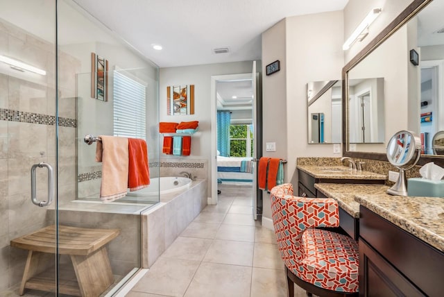 bathroom with tile patterned flooring, vanity, and shower with separate bathtub