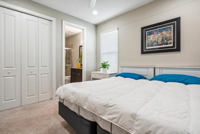 carpeted bedroom with ensuite bath, a closet, and ceiling fan