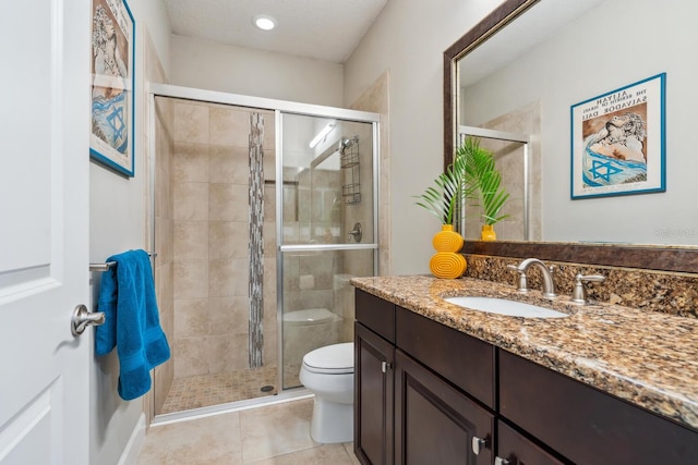 bathroom featuring vanity, toilet, an enclosed shower, and tile patterned flooring