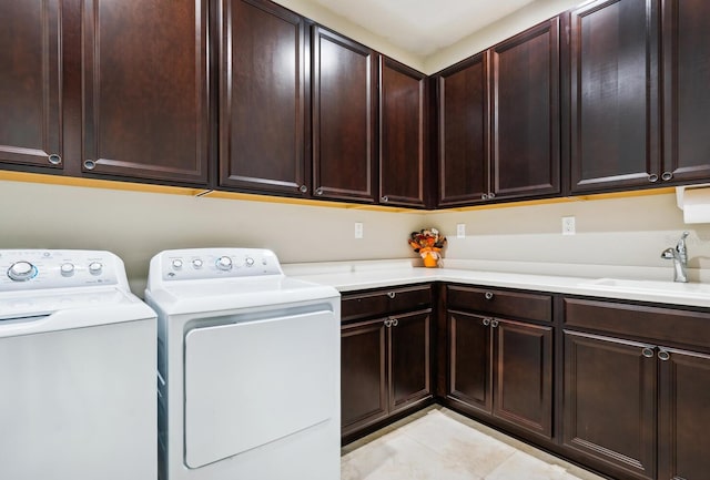 laundry area featuring cabinets, light tile patterned floors, sink, and washing machine and clothes dryer