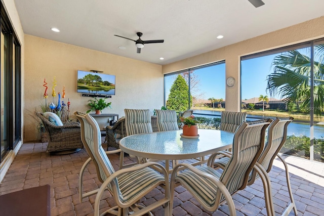 sunroom / solarium featuring a wealth of natural light and ceiling fan