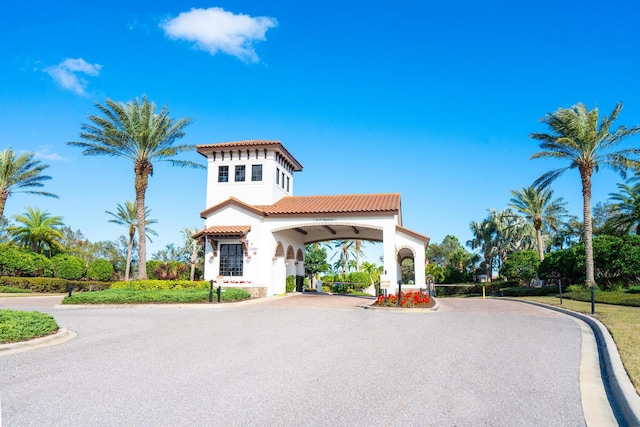 view of front facade with aphalt driveway, a tiled roof, and stucco siding