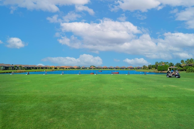 surrounding community with a water view and a yard