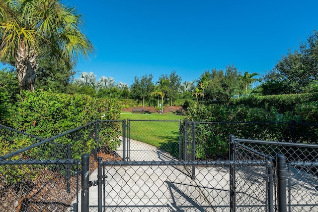 view of gate with fence and a yard