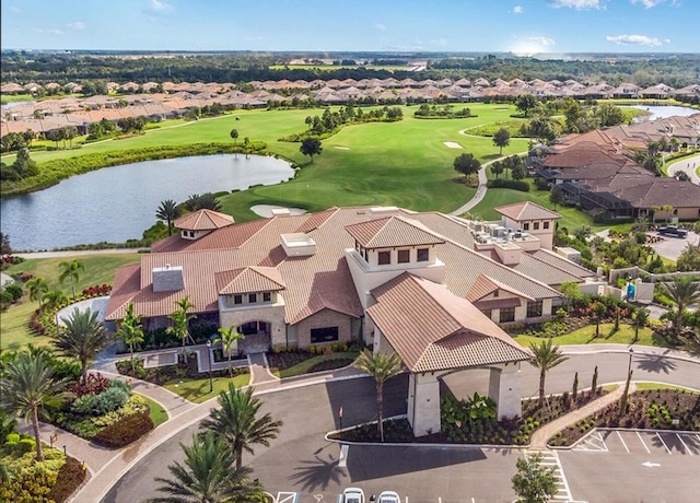 drone / aerial view with a residential view, view of golf course, and a water view