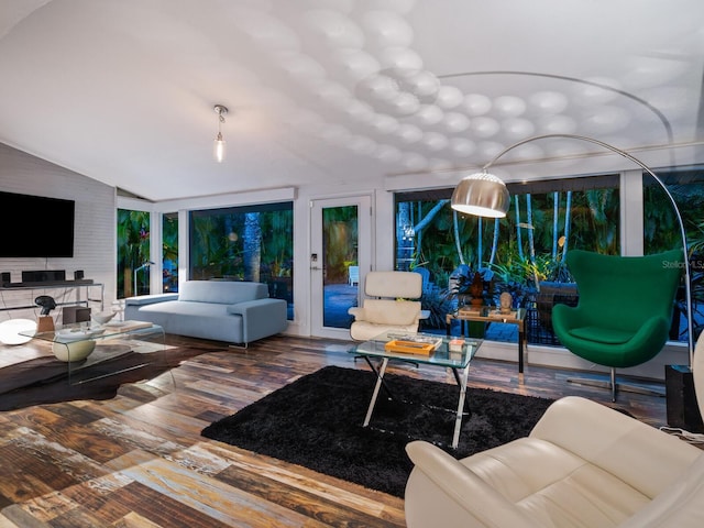 living area featuring vaulted ceiling and wood finished floors