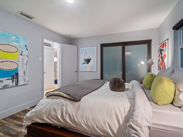 bedroom featuring dark wood-style flooring, visible vents, and baseboards