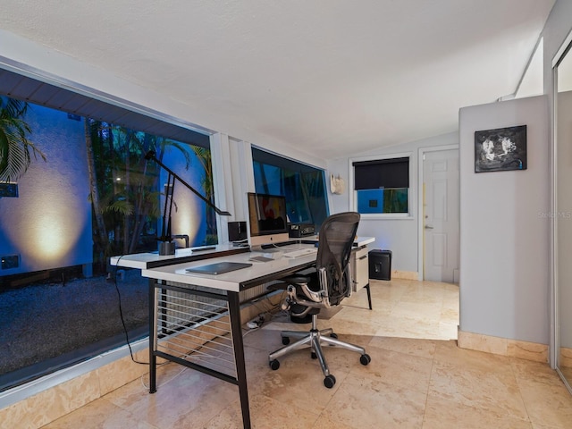 office space featuring lofted ceiling and baseboards