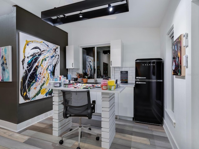 home office featuring light wood-type flooring and baseboards