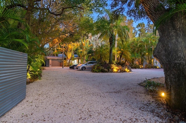 view of yard featuring gravel driveway and a garage