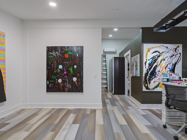 interior space featuring recessed lighting, baseboards, wood finished floors, and a wall mounted AC