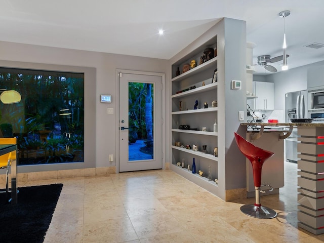 foyer entrance featuring ceiling fan and visible vents