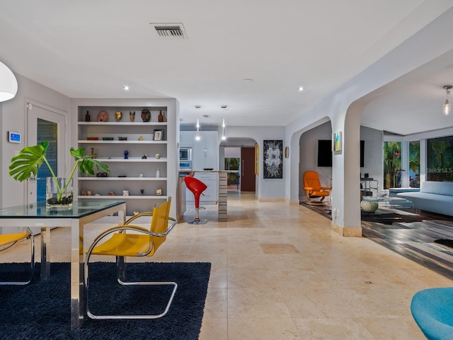 dining room with built in features, arched walkways, visible vents, and tile patterned floors