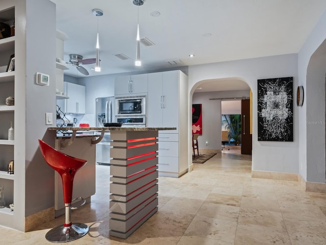 kitchen featuring visible vents, arched walkways, a ceiling fan, appliances with stainless steel finishes, and decorative light fixtures