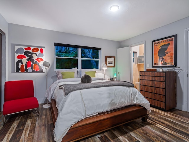 bedroom with connected bathroom and wood finished floors