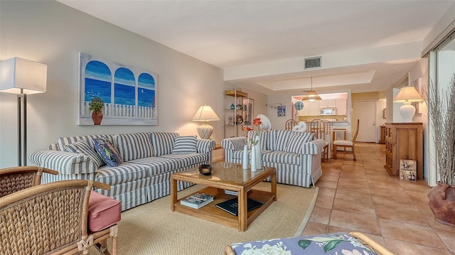 living room with tile patterned floors and a tray ceiling