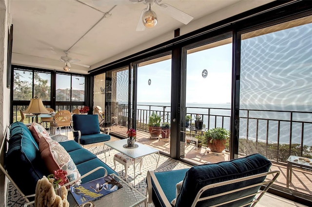 sunroom / solarium featuring a healthy amount of sunlight, a water view, and ceiling fan