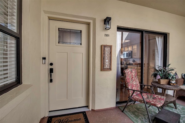 doorway to property featuring stucco siding