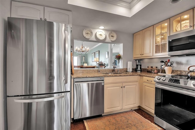 kitchen featuring glass insert cabinets, appliances with stainless steel finishes, dark wood-style flooring, and ornamental molding