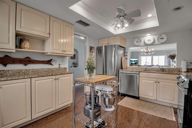 kitchen featuring wood finished floors, a sink, visible vents, appliances with stainless steel finishes, and a tray ceiling