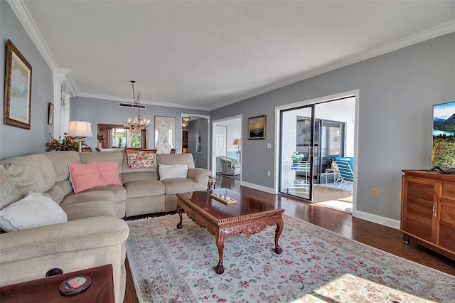 living area featuring baseboards, crown molding, dark wood finished floors, and an inviting chandelier