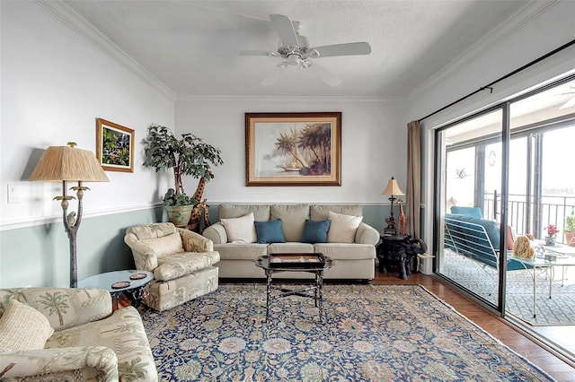 living room with a ceiling fan, a textured ceiling, ornamental molding, and wood finished floors