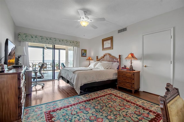 bedroom featuring access to exterior, a textured ceiling, visible vents, and wood finished floors