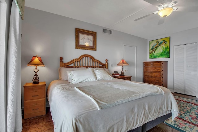 bedroom with ceiling fan, a closet, wood finished floors, and visible vents