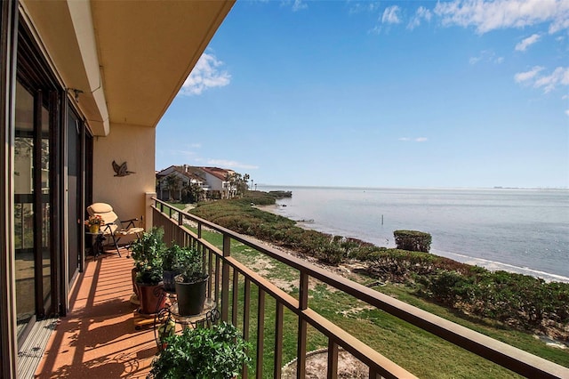 balcony with a water view and a view of the beach